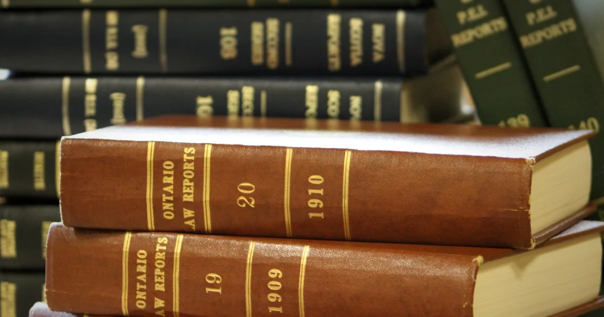 Volumes encadernados de repertórios de jurisprudência sobre uma mesa